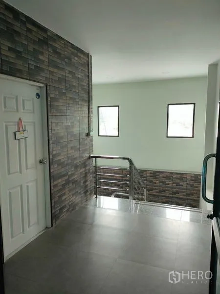 Factory for rent in Ban Phaeo, Samut Sakhon - Upper landing with stainless-steel handrails and tiled feature wall.