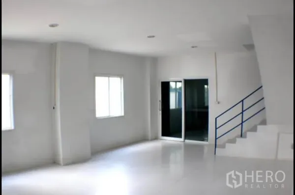 Factory for rent in Pak Kret, Nonthaburi - Open-plan office space with windows, recessed lighting and blue-railed stairs.