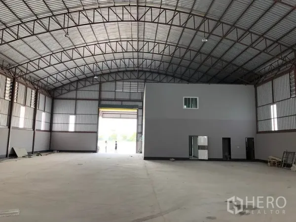 Factory for rent or sale in Bang Len, Nakhon Pathom - Warehouse hall facing the loading door with an internal office block and wide open floor area.