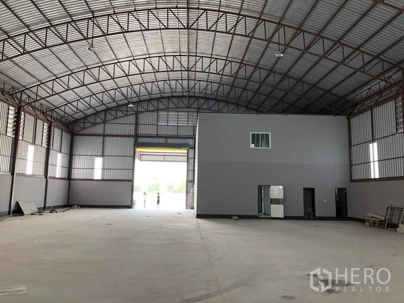 Factory for rent or sale in Bang Len, Nakhon Pathom - Warehouse hall facing the loading door with an internal office block and wide open floor area.