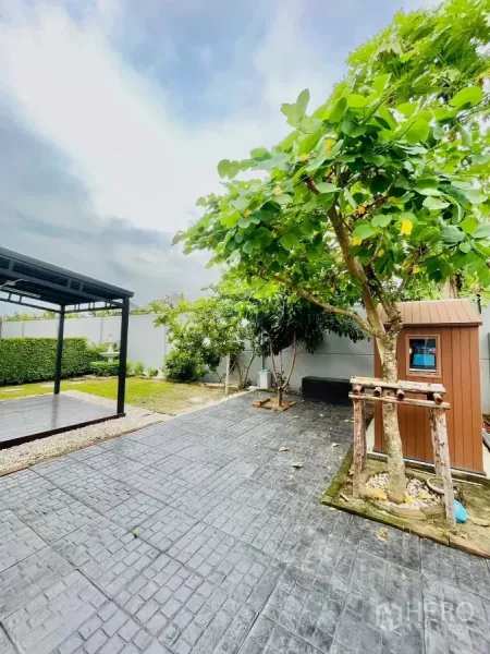 Detached House for rent in Prawet, Bangkok - Paved patio beside mature trees with a storage shed and open-frame gazebo.