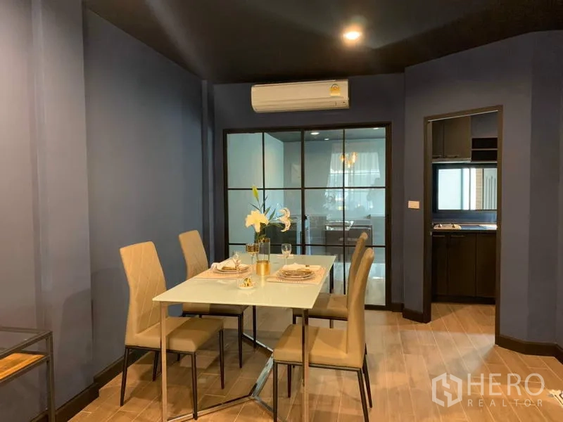 Townhouse for rent in Bang Kapi, Bangkok - Dining space with glass partition, air conditioner and access to the kitchen.