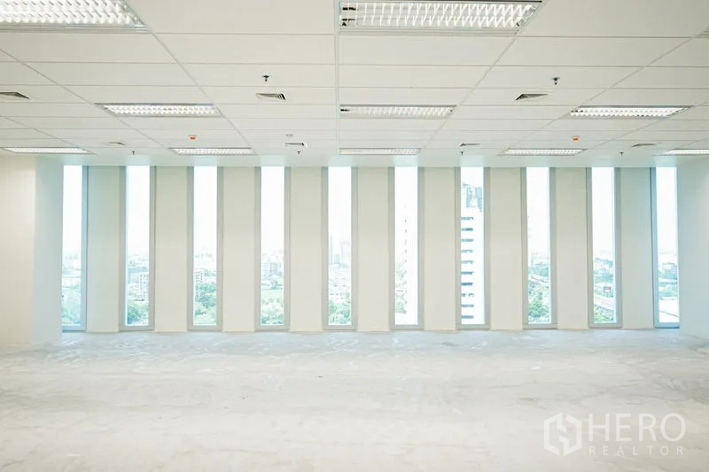 Office Space for rent in Bang Na, Bangkok - Panoramic office view facing a row of full-height narrow windows overlooking the Bang Na skyline.