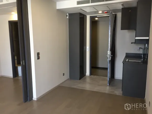 Condominium for sale in Watthana, Bangkok - Open-plan living area with sliding door to bedroom and built-in pantry.