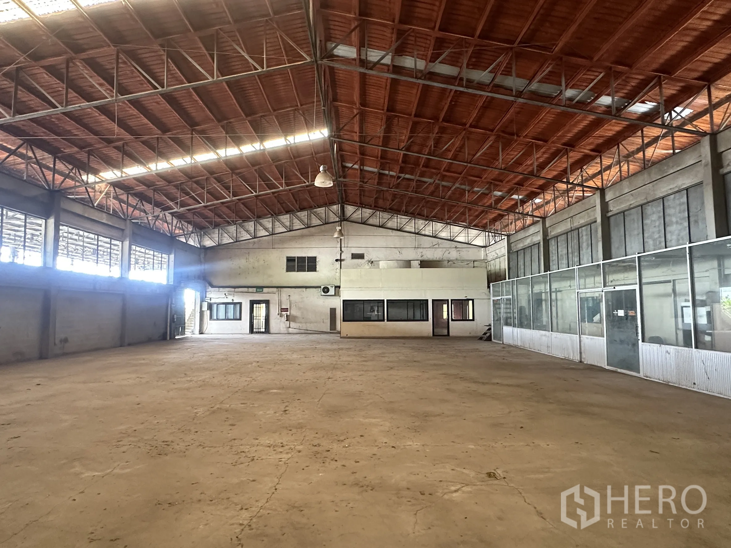 工厂 for sale in Sai Noi, Nonthaburi - 厂房内部一侧为封闭式办公室与大面积窗户。