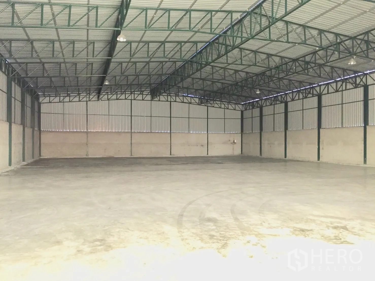 Warehouse for rent in Si Racha, Chon Buri - Spacious warehouse interior with high steel truss roof and polished concrete floor.