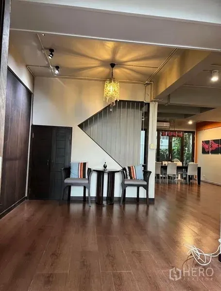 Townhouse for rent in Phaya Thai, Bangkok - Cozy seating nook under the staircase with pendant light and wood flooring.