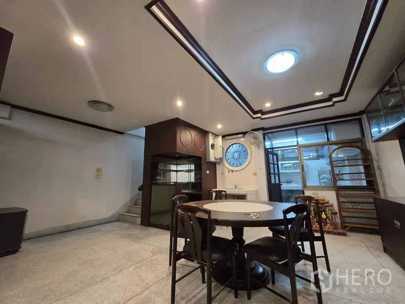 Home Office for rent in Sathon, Bangkok - Dining or meeting zone by the staircase with ceiling spotlights and a round window.