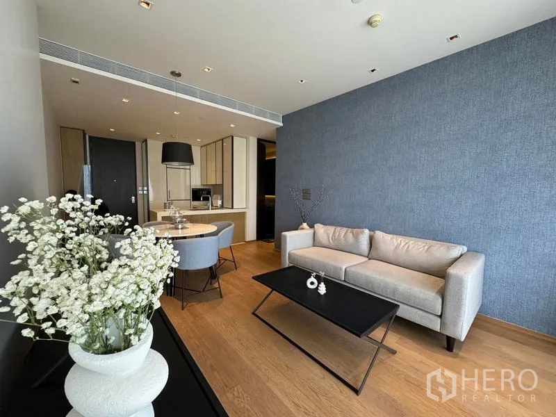 Condominium for rent - Contemporary living room with light gray sofa and black coffee table on wood floor.