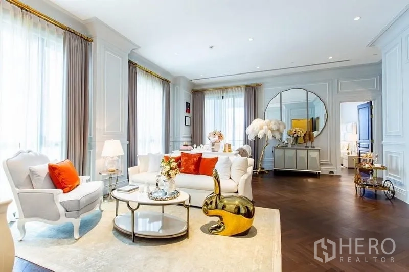 Condominium for sale in Pathum Wan, Bangkok - Elegant lounge with round mirror, gold decor and city-light windows in a 132 sqm Bangkok condominium.