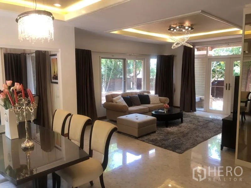 Detached House for rent or sale in Pak Kret, Nonthaburi - Bright lounge with corner sofa and sliding doors opening to the patio and garden.