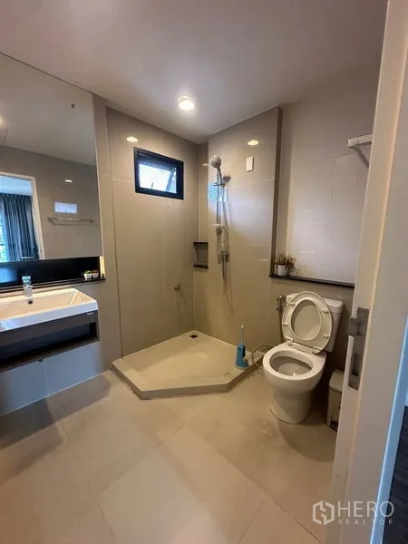 Detached House for rent in Lam Luk Ka, Pathum Thani - Modern bathroom with walk-in shower, large mirror and toilet.