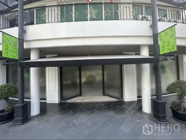 Office Space for rent in Khlong Toei, Bangkok - Canopied main entrance flanked by columns and green signboards with wide storefront windows.