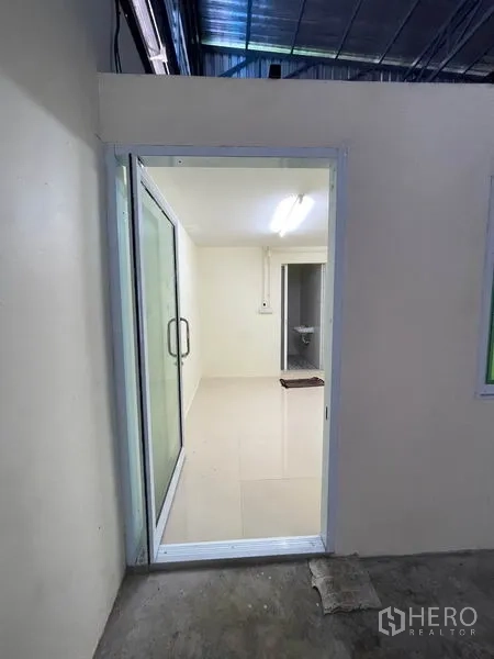 Warehouse for rent in Khlong Luang, Pathum Thani - Sliding glass door entry to internal office from the warehouse floor.