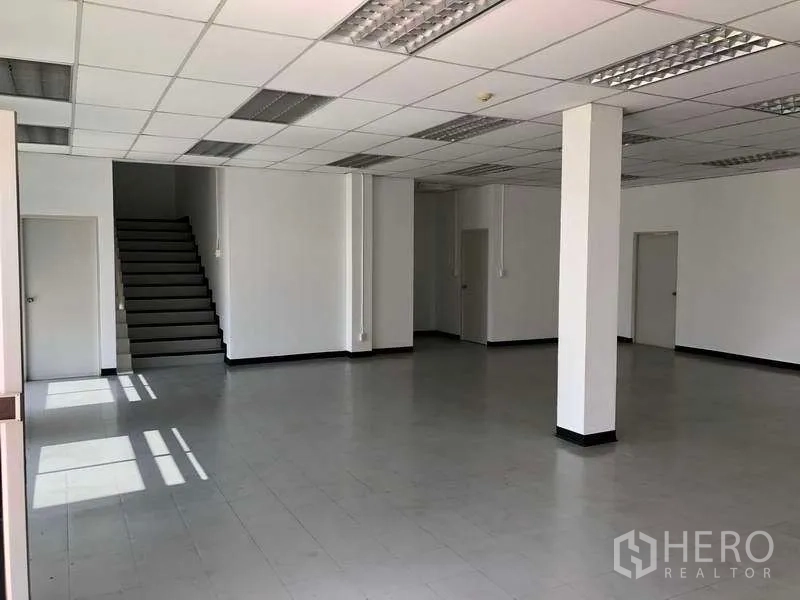 Factory for rent or sale in Phra Nakhon Si Ayutthaya - Open-plan office space with suspended ceiling, tiled floor and multiple doorways.