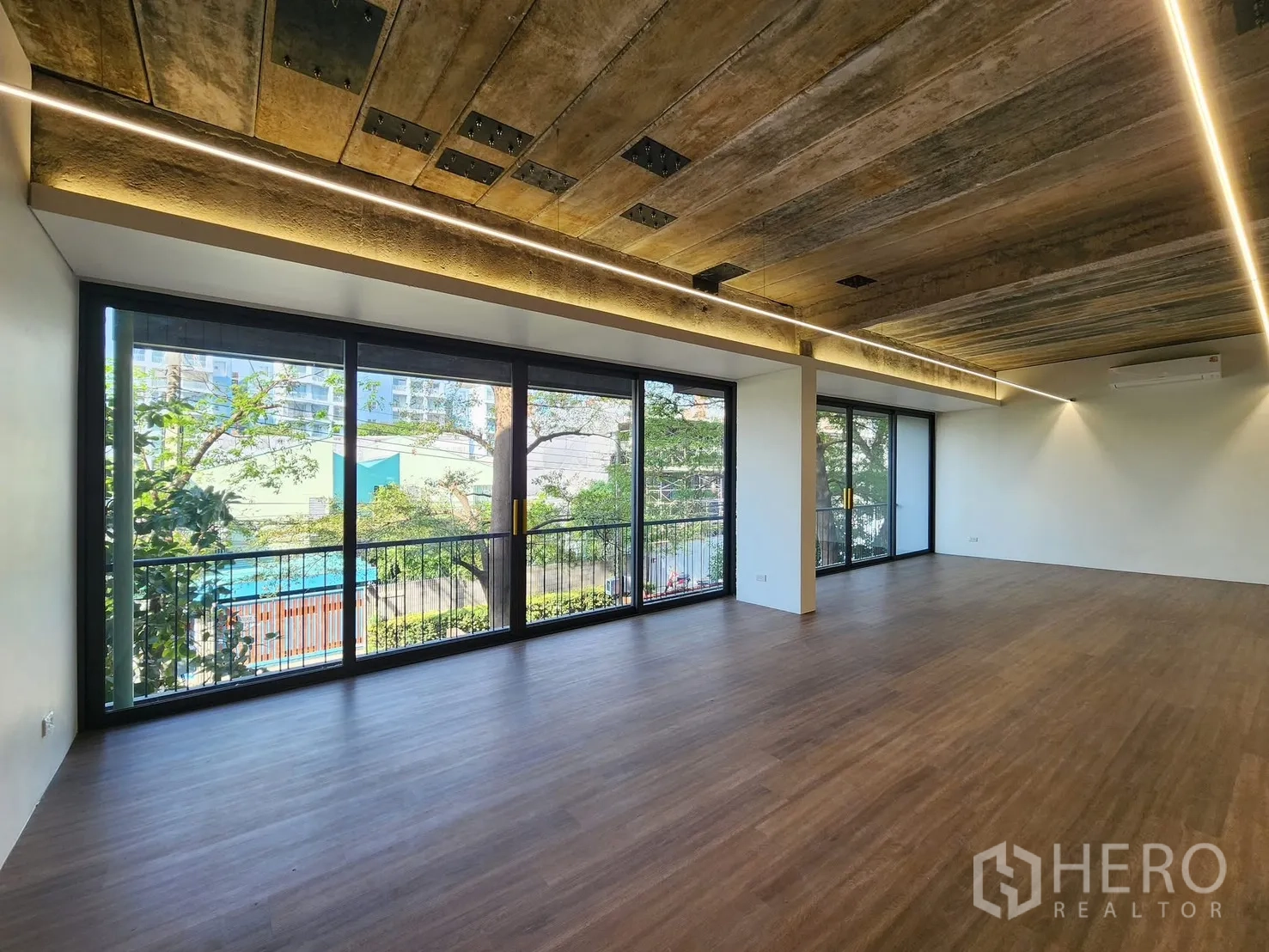 Home Office for rent in Chatuchak, Bangkok - Corner office with floor-to-ceiling windows, long balcony, and treetop outlook.