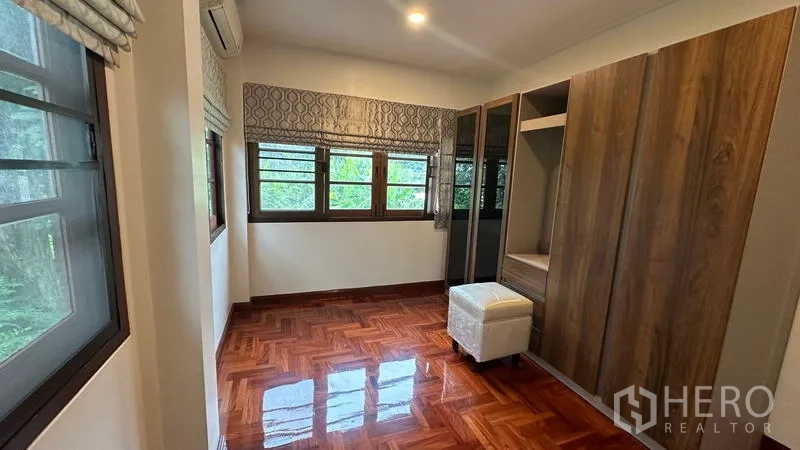 Detached House for rent in Watthana, Bangkok - Corner bedroom with wardrobes, multiple windows and air-conditioning.