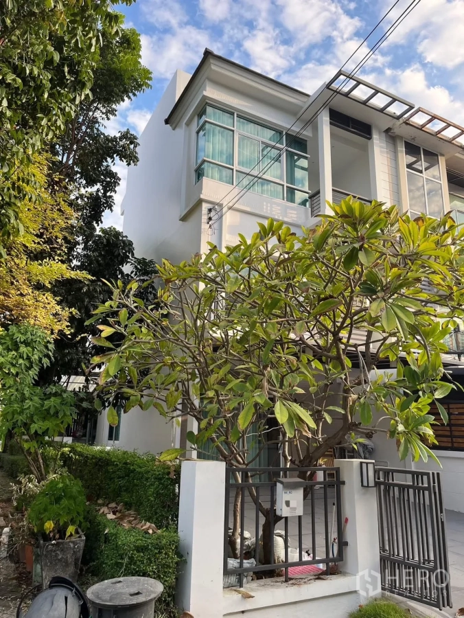 Townhouse for rent in Prawet, Bangkok - Three-storey corner townhouse facade with gated front garden.