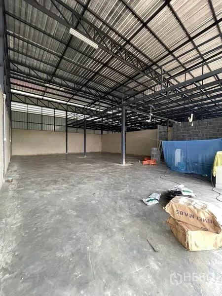 Warehouse for rent in Pathum Thani - Open-plan warehouse interior with steel posts and unfinished utilities.