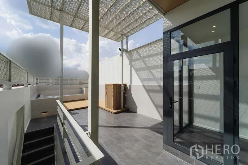 Townhouse for rent or sale in Watthana, Bangkok - Rooftop terrace walkway with shade trellis and patterned privacy screens.