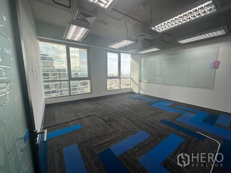 Office Space for rent in Bang Rak, Bangkok - Private office with large windows, a whiteboard wall, and skyline views.