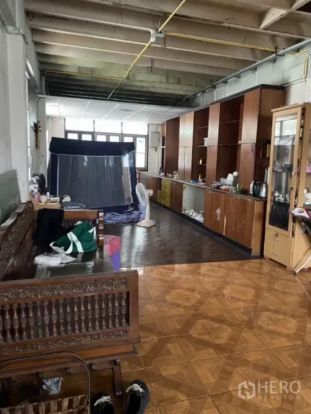 Shophouse for rent in Khlong Toei, Bangkok - Open-plan level with built-in wooden cabinets and patterned floor tiles.