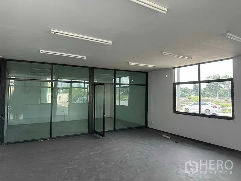 Warehouse for rent in Khlong Luang, Pathum Thani - Office area with large windows facing the road and internal glass meeting rooms.