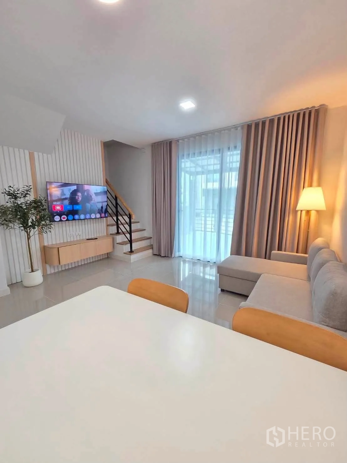 联排别墅 for rent in Bang Phli, Samut Prakan - 开放式客餐厅，沙发、墙挂电视、餐桌与楼梯。