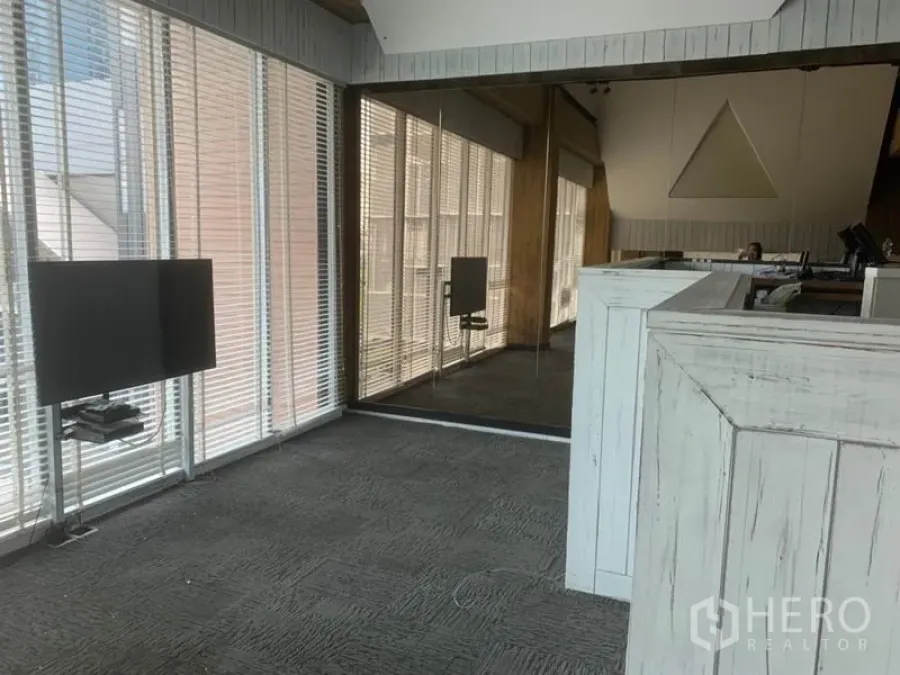 Retail Space for rent in Watthana, Bangkok - Loft-style retail interior with floor-to-ceiling windows, blinds, mirrored wall and a rustic counter.