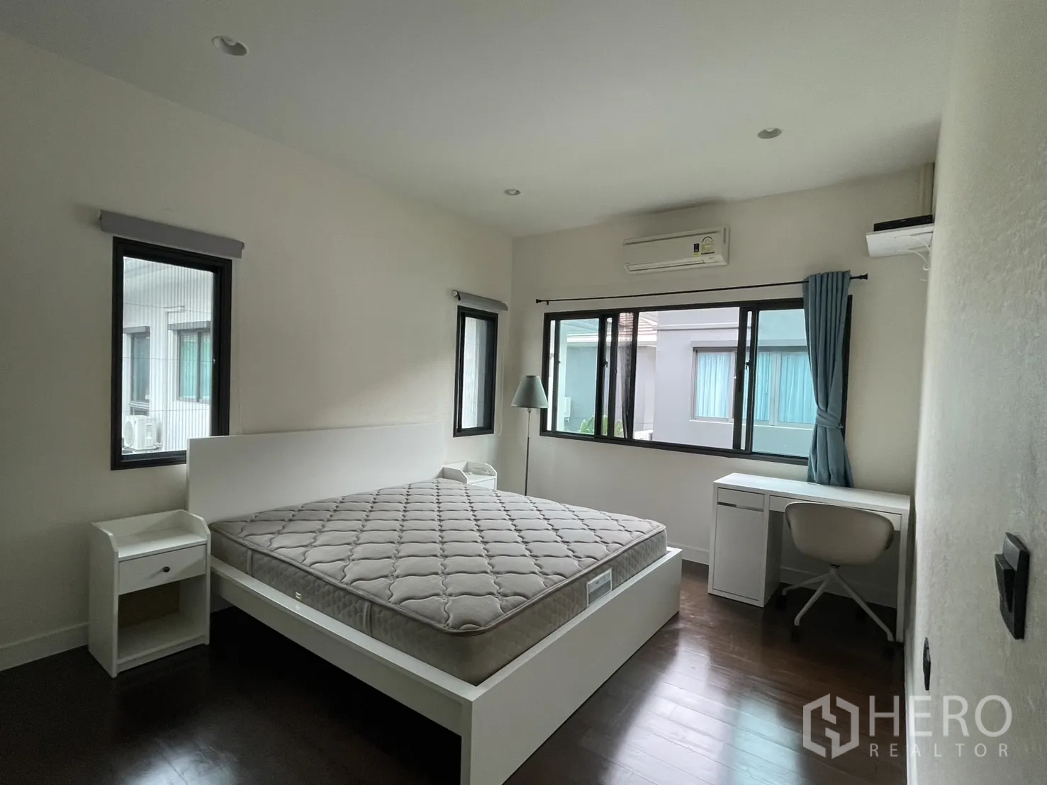 Detached House for rent in Bang Kapi, Bangkok - Bright bedroom with bed, desk and air conditioning, multiple windows.