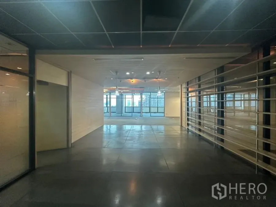Office Space for rent in Khlong Toei, Bangkok - Lobby view toward open office with overhead spotlights and large windows in the distance.