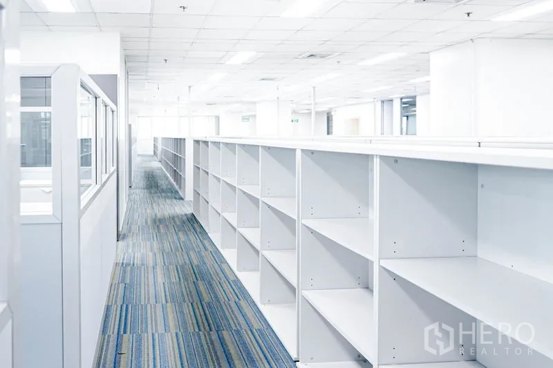 Office Space for rent in Watthana, Bangkok - Aisle of built-in open shelving units across the office floor.
