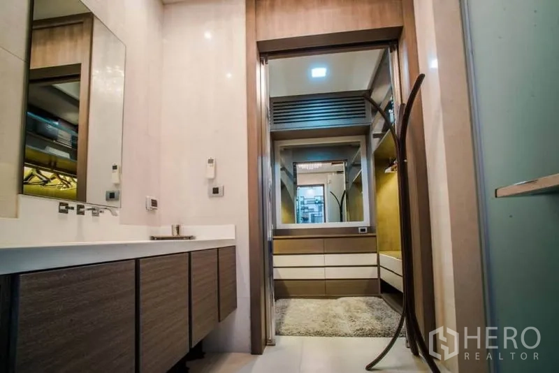 Townhouse for rent or sale in Watthana, Bangkok - Contemporary bathroom with double vanities leading to a walk-in closet