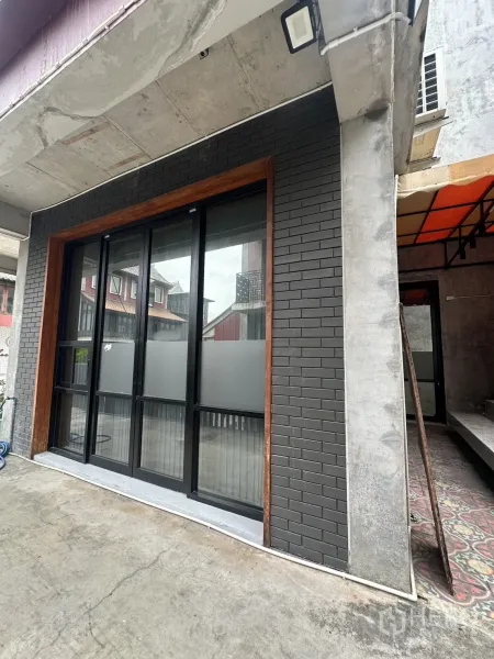 Home Office for rent in Pathum Wan, Bangkok - Ground-floor storefront with black brick wall and sliding glass door under a concrete overhang.