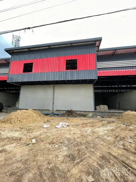 Warehouse for rent in Pathum Thani - Front block with red and gray cladding above solid walls during construction.