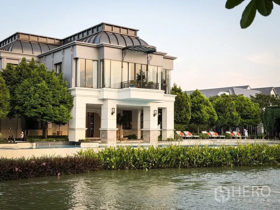 Detached House for rent in Bang Khen, Bangkok - Lakeside clubhouse with outdoor swimming pool, sun loungers and lush greenery.