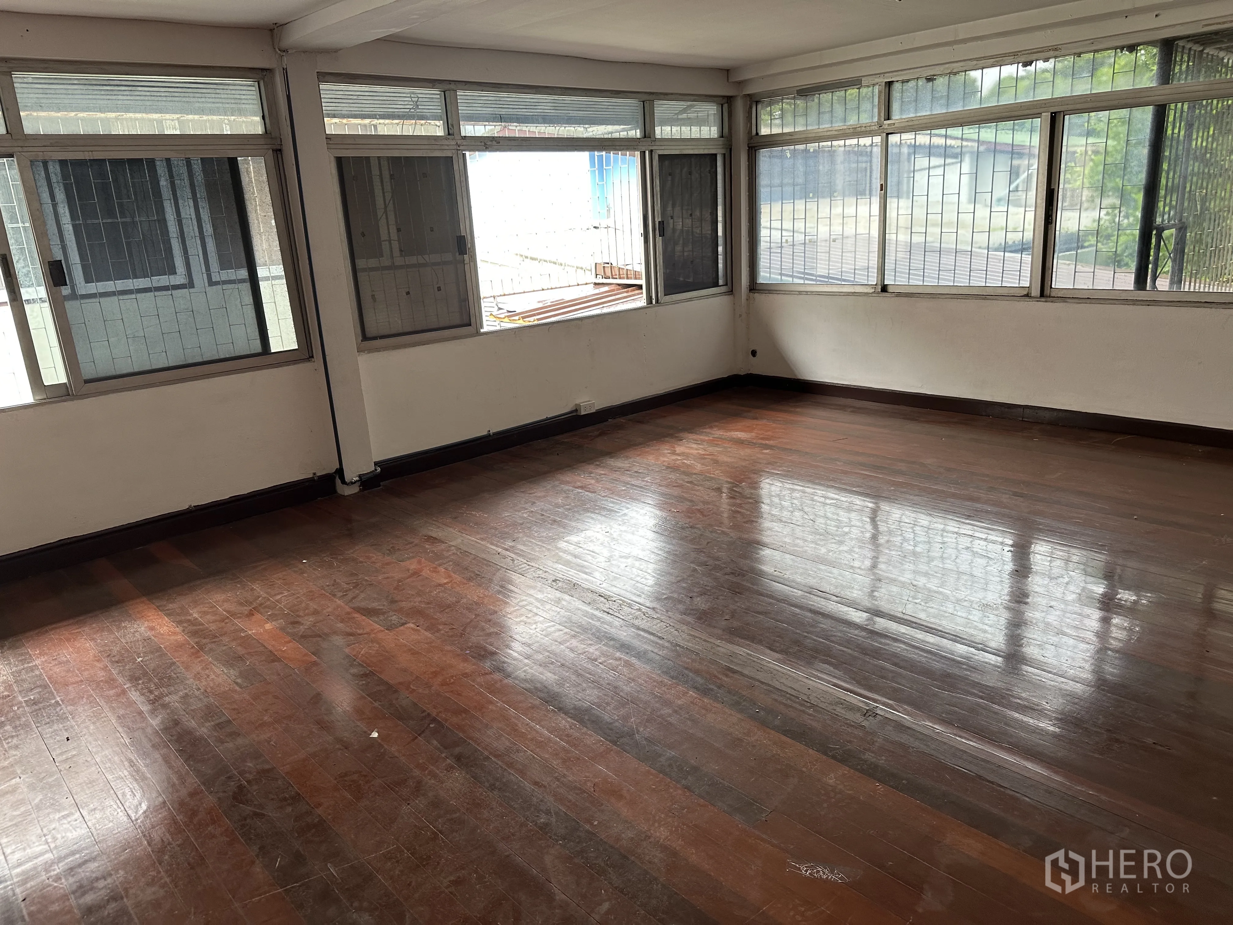 Home Office for rent in Suan Luang, Bangkok - Spacious corner room with polished wood flooring and wraparound windows.
