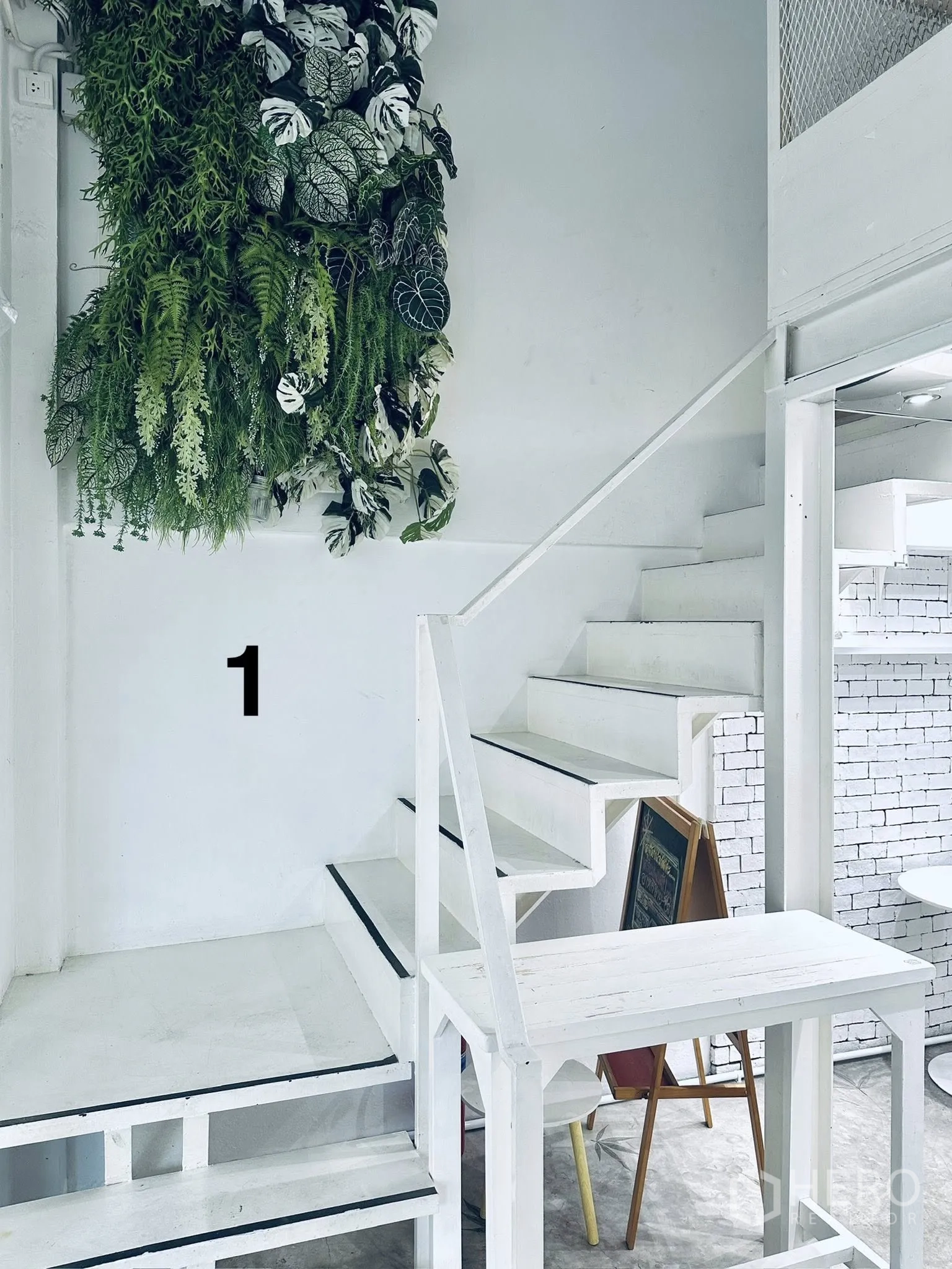 Shophouse for rent in Watthana, Bangkok - White staircase beside a vertical garden feature leading to the upper levels.