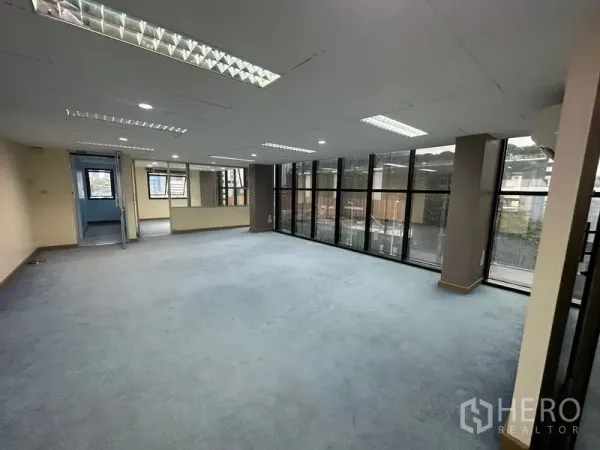 办公空间 出租在Bang Rak, Bangkok - 开阔的开放式办公区，地毯地面，嵌入式日光灯和整面落地窗。