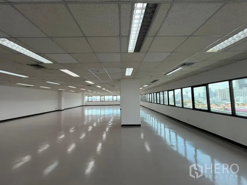 Office Space for rent or sale - Open‑plan office with panoramic strip windows, suspended ceiling, AC vents and city views.