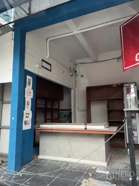 零售空间 出租或出售在Watthana, Bangkok - 开敞式店铺前场，蓝色立柱、服务台与壁柜，待二次装修。