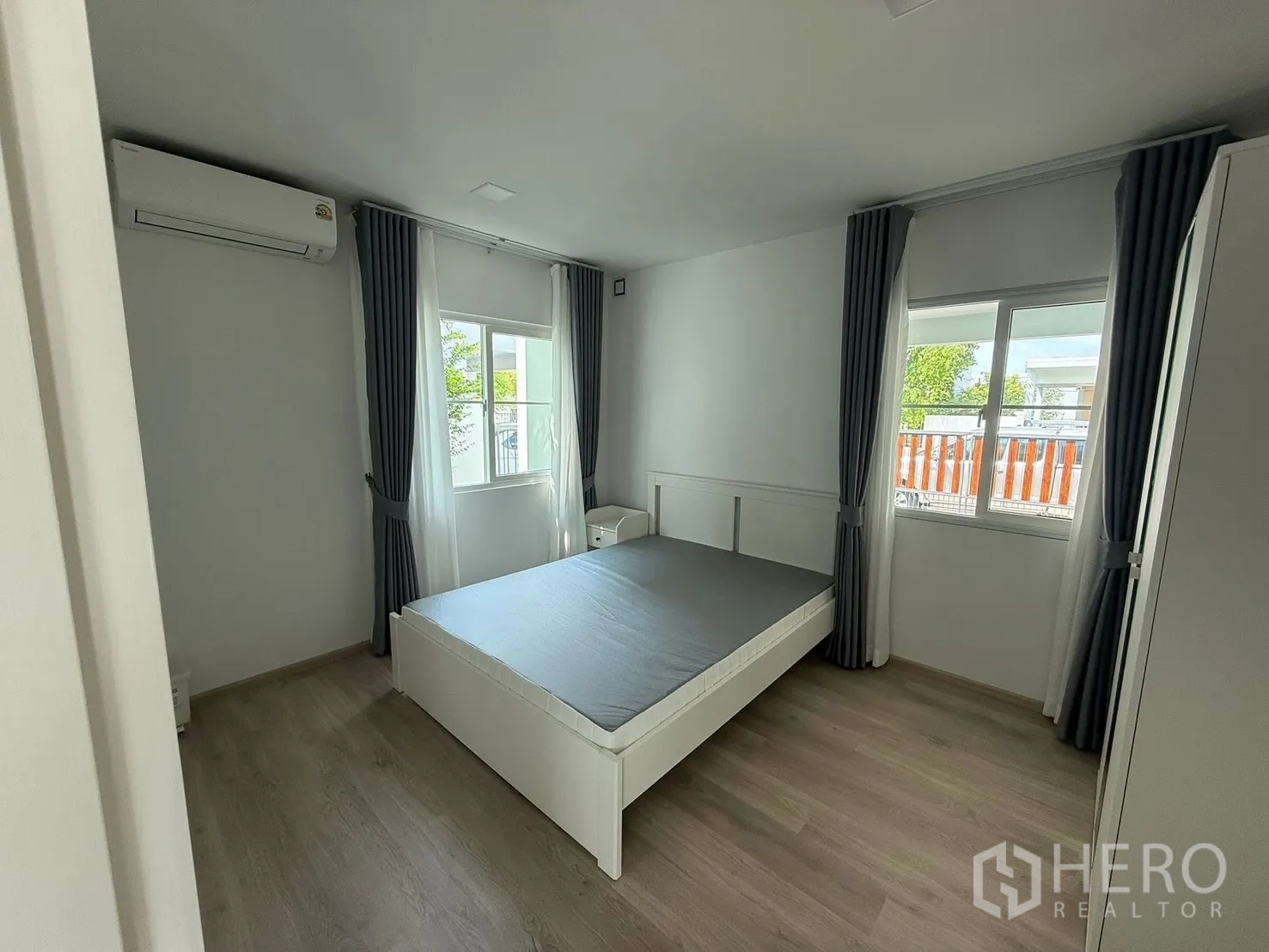 Detached House for rent in Bang Phli, Samut Prakan - Bright bedroom with a double bed, windows with curtains, wardrobe, and an air conditioner.