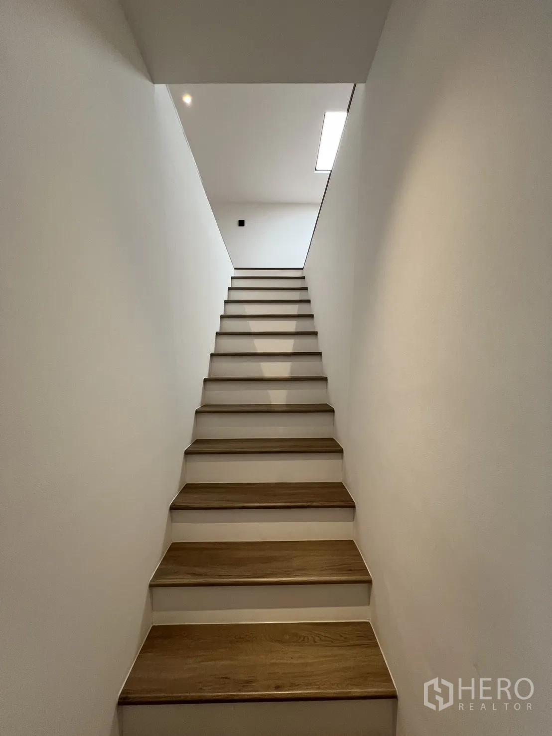Townhouse for sale in Watthana, Bangkok - Loft room with skylight, wood floors and flexible sleeping or lounge area.