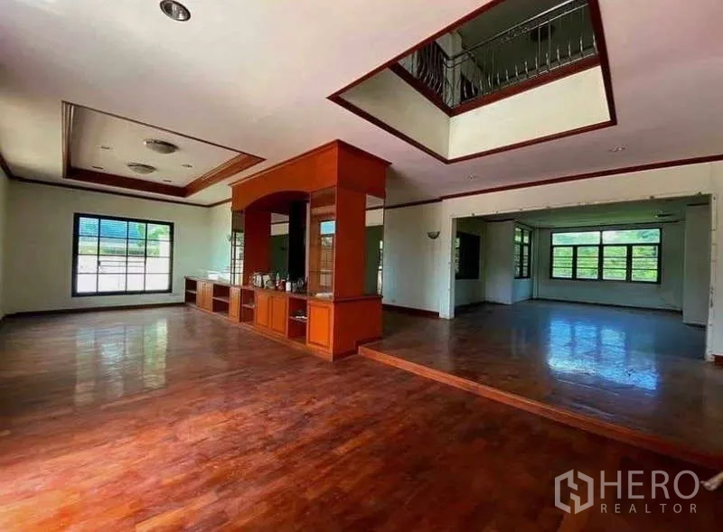 Detached House for sale in Prawet, Bangkok - Open-plan living room with built-in wood cabinetry and coffered ceilings.