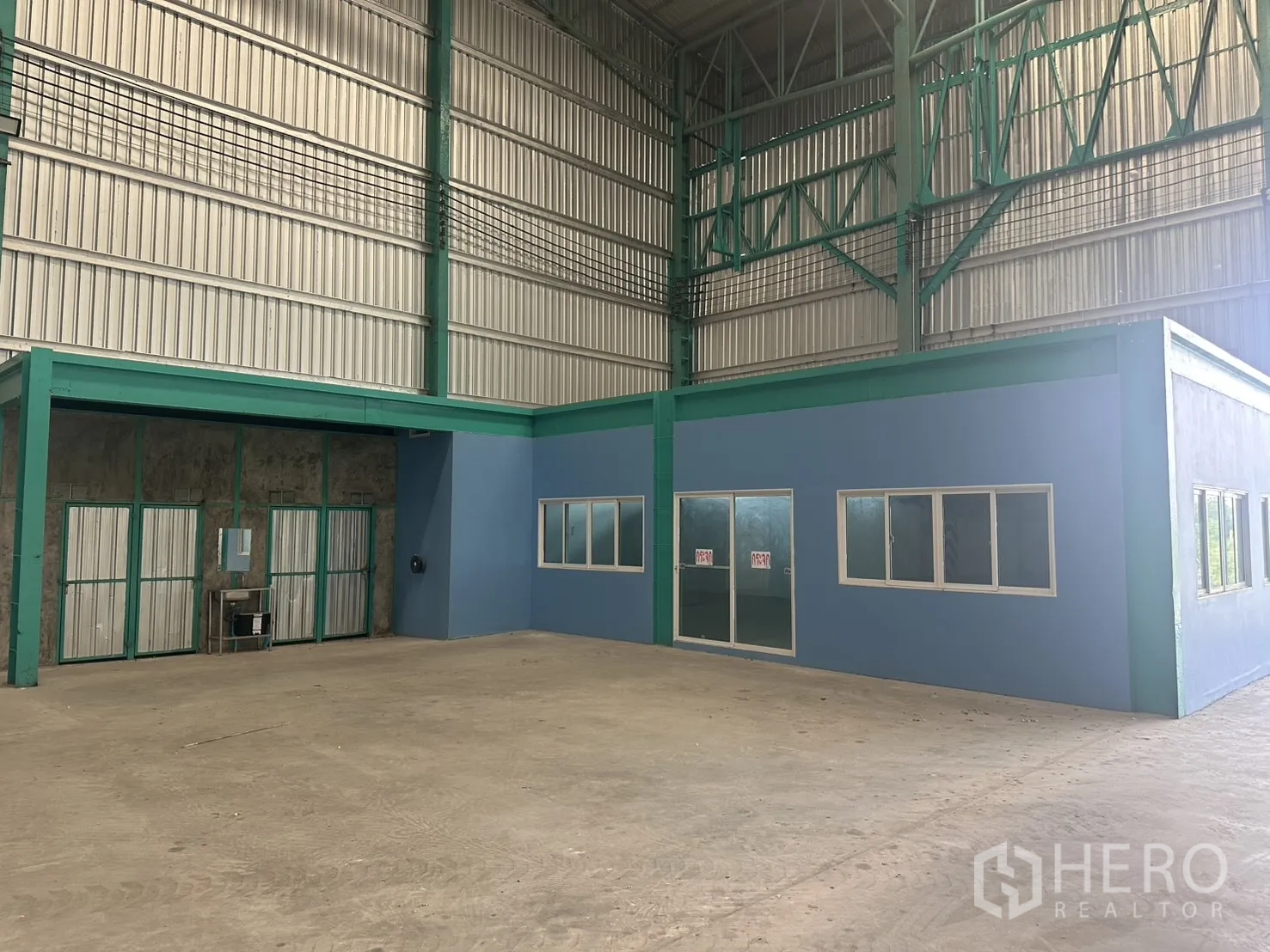 Warehouse for rent in Sai Noi, Nonthaburi - Interior view showing an enclosed office block with windows and double doors inside the warehouse.
