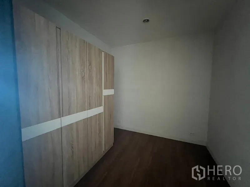 Townhouse for rent or sale in Khlong Toei, Bangkok - Small bedroom fitted with large wood wardrobes and laminate floor.