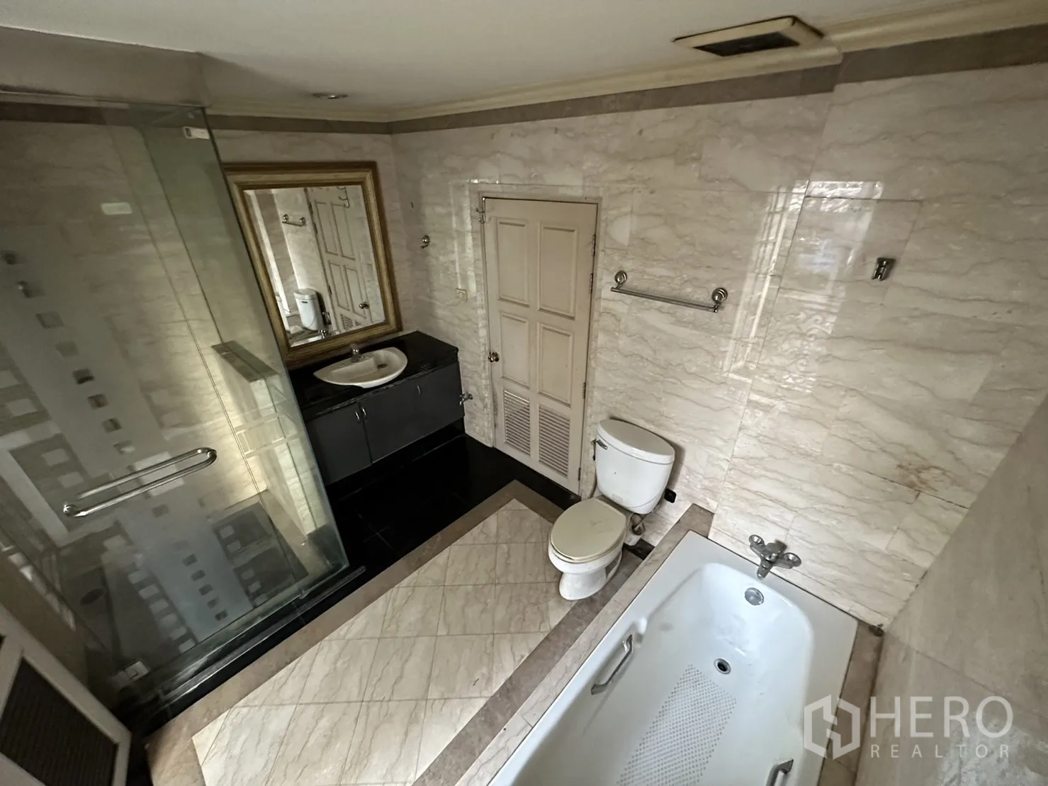 Home Office for rent in Huai Khwang, Bangkok - Bathroom with glass shower, bathtub, marble walls and vanity.