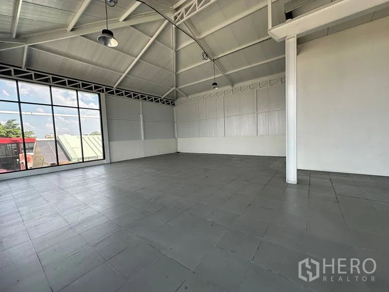 零售空间 出租在Bang Na, Bangkok - 宽敞室内，大片窗墙、山形屋顶与工业吊灯，墙面简洁素雅。