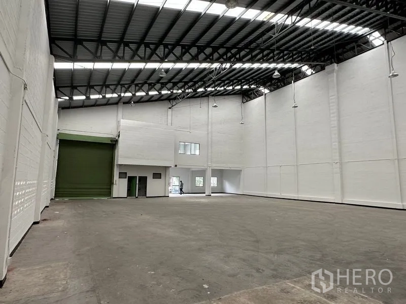 工厂 出租在Khlong Luang, Pathum Thani - 宽阔生产区域，高位照明与钢屋顶，后方设办公室及装卸区通道。