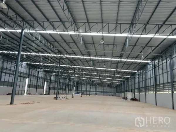 货栈 出租在Lat Krabang, Bangkok - 仓库内部空间宽敞，高钢结构屋顶与采光带，适合仓储或物流作业。